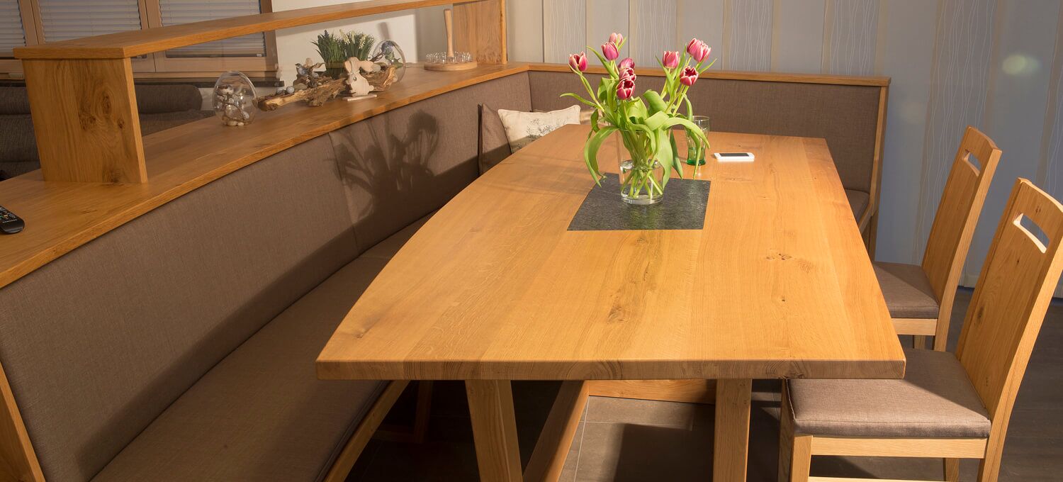 Tisch mit Kufengestell und Steinplatte in der Mitte, samt Eckbank in Eiche und Stoffbezug