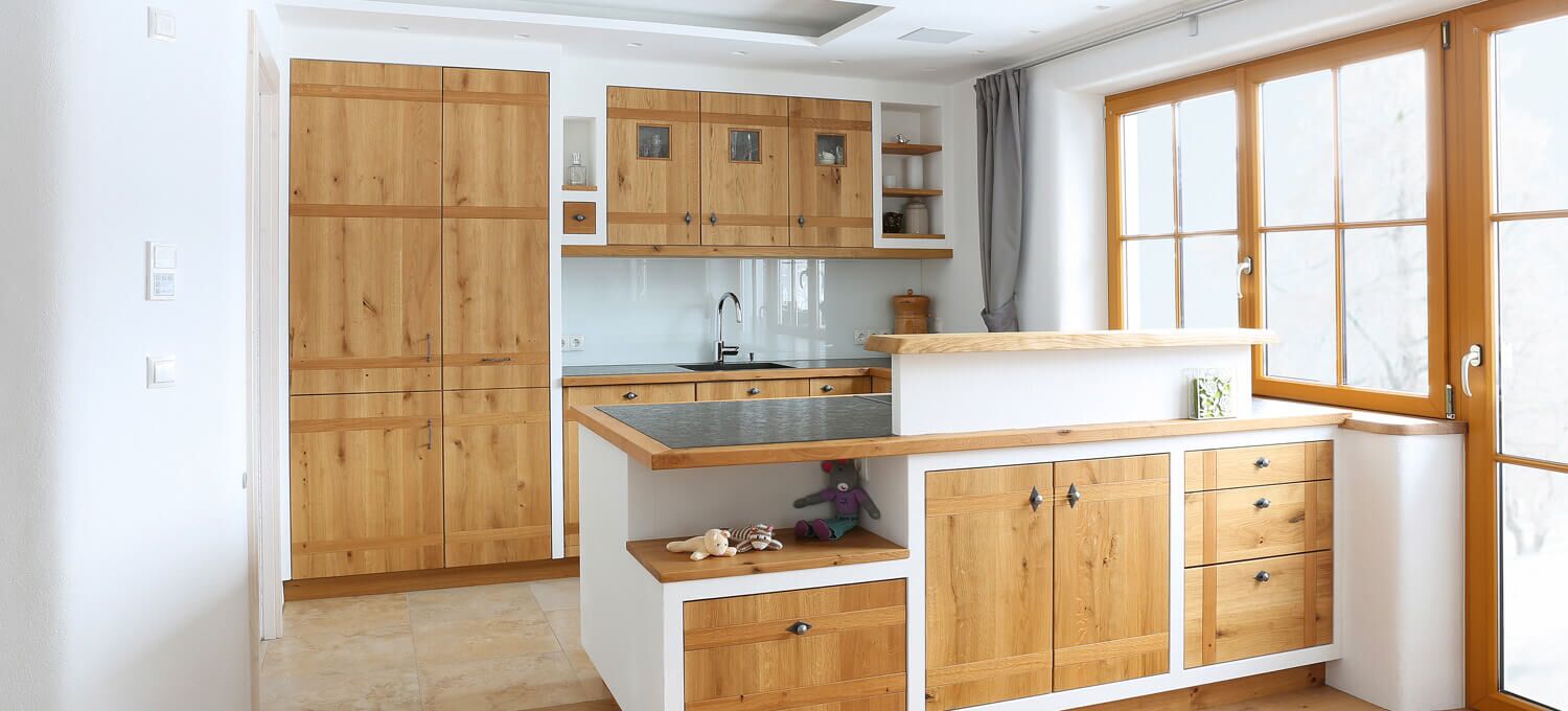 Traditionelle Küche mit Massivholzfronten und Mauereinfassung, Arbeitsplatte Naturstein mit Massivholzumrahmung