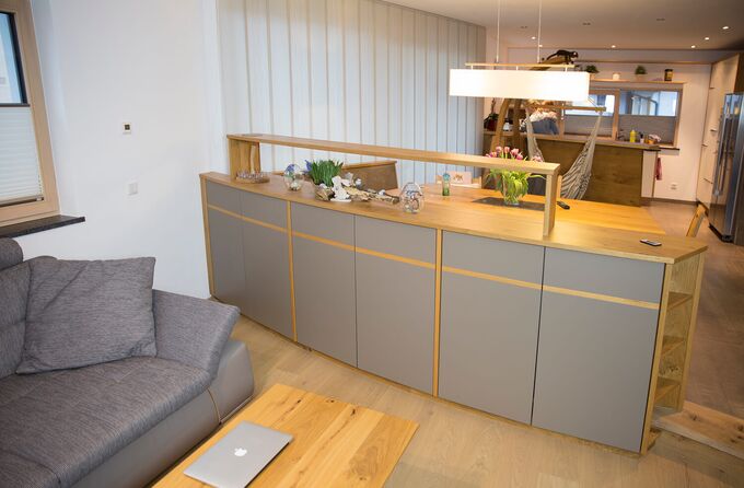 Runder Raumteiler mit viel Stauraum in Eiche und TipOn Drehtüren in grauem Dekor und Holzleiste