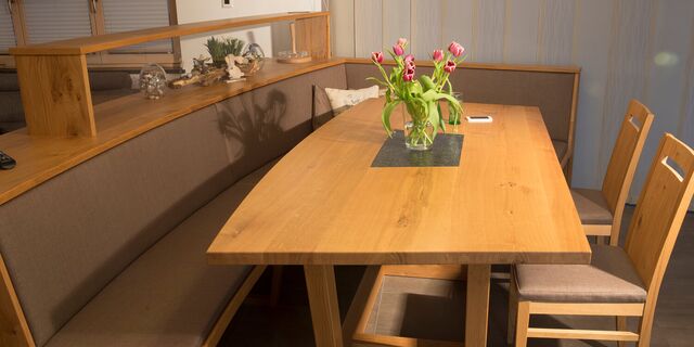 Tisch mit Kufengestell und Steinplatte in der Mitte, samt Eckbank in Eiche und Stoffbezug