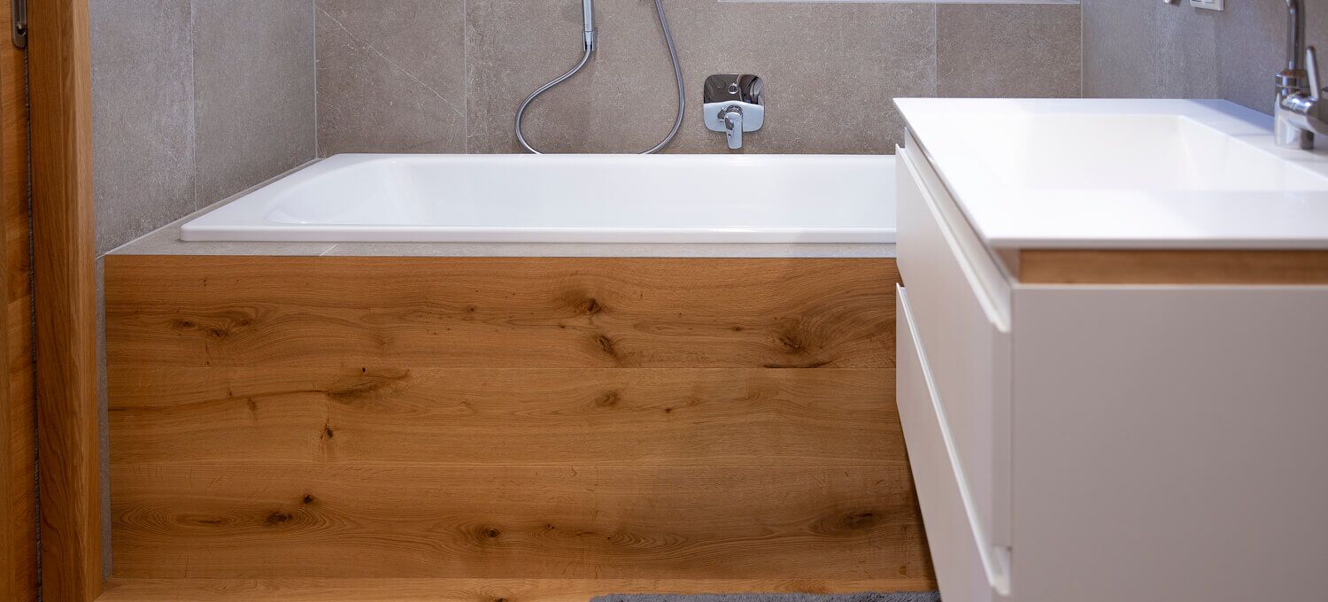 Ein Badezimmer mit Blick auf einen Badewannenverbau in Eiche